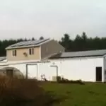 Kenyon Growers 2 Kenyon-Growers farm buildings on a rural landscape, featuring white structures and metal roofing amid grass and distant trees