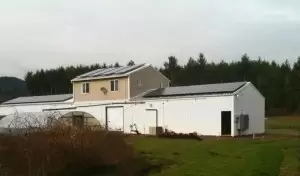 Kenyon-Growers farm buildings on a rural landscape, featuring white structures and metal roofing amid grass and distant trees